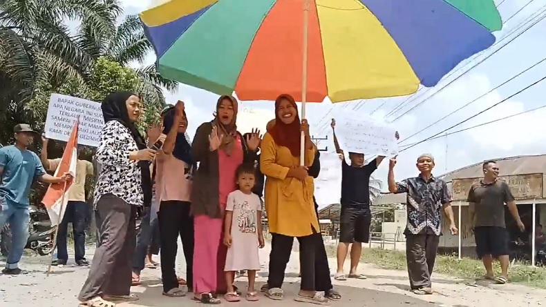 Sindir Pemerintah, Emak-Emak Pakai Payung Besar Mendadak Jadi Model di Tengah Jalan Asahan