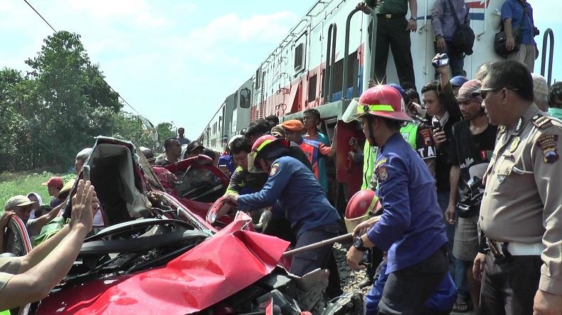 toyota tertabrak kereta2 Petugas Damkar dibantu polisi dan warga mengevakuasi suami istri yang terjepit di mobil setelah tertabrak KA Kaligung di perlintasan tanpa palang pintu di Desa Sidorejo, Kecamatan Brangsong, Kabupaten Kendal, Jateng, Senin (9/12/2019). (Foto: iNews/E