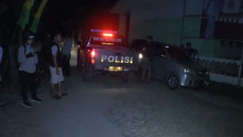Polisi berjaga-jaga di sekitar rumah pelaku penikaman siswa SMK berinisial U (15) di Desa Pasiang, Kecamatan Matakali, Kabupaten Polewali Mandar, Sulawesi Barat (Sulbar), Selasa (18/12/2019) malam. (Foto: iNews/Huzair Zainal)