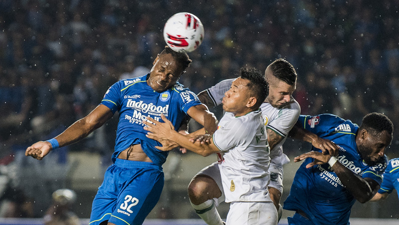 Persib Igbonefo Bek Persib Bandung Victor Igbonefo (kiri) berduel udara dengan defender PSS Sleman Asyraq Gufran Ramadhan (kedua kiri) dan Aaron Evans pada pekan ketiga di Stadion Si Jalak Harupat, Minggu (15/3/2020) malam. (Foto: ANTARA/M Agung Rajasa)