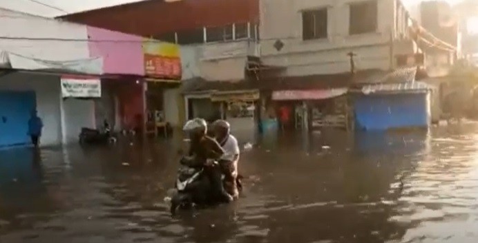 29 Banjir Depok Pengendara motor terjebak banjir di ruas Jalan AR Hakim Kota Depok. (Foto: iNews/Iyung Rizki)