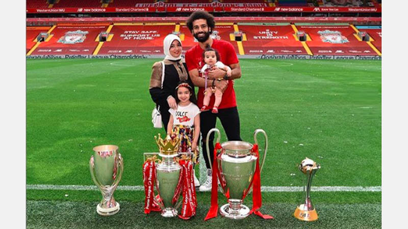 Mohamed Salah dan istri Mohamed Salah mengajak istrinya, Magi, dan kedua putri mereka, berfoto bersama empat trofi yang diraih Liverpool musim ini. (Foto: Instagram @mosalah)