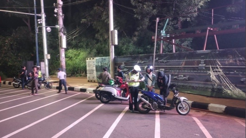 Polisi membubarkan kerumunan pengendara motor di Jalan Gerbang Pemuda Senayan, Jakarta Selatan, Sabtu (22/8/2020) dini hari ini. (Foto: TMC Polda Metro).