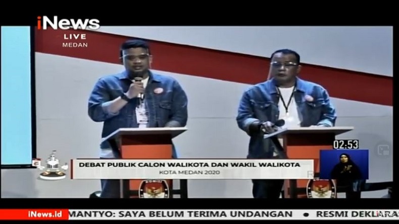 Paslon Wali Kota-Wakil Wali Kota Medan Nomor Urut 2, Muhammad Bobby Afif Nasution - Aulia Rachman tampil kasual dengan jaket denim saat debat publik perdana, Sabtu (7/11/2020). (iNews)