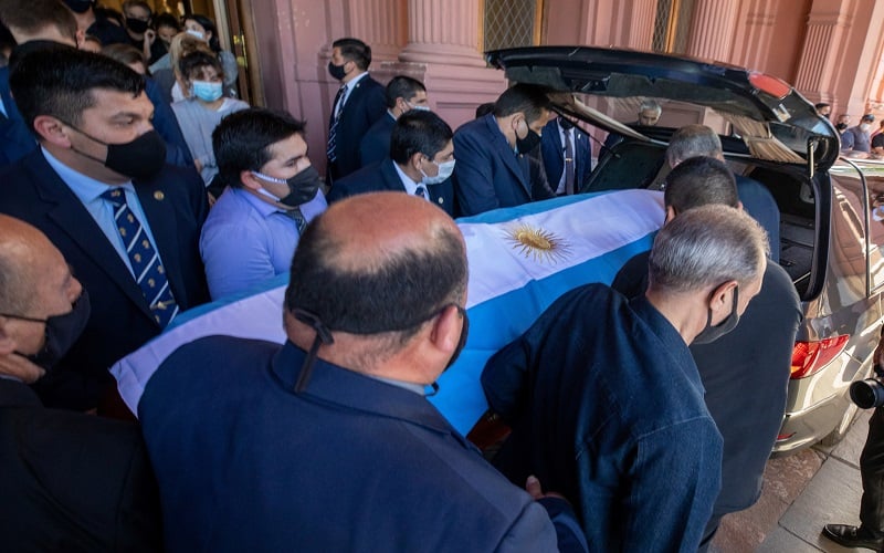 Sejumlah orang memasukkan peti mati berisi jenazah Diego Maradona ke dalam mobil yang membawanya ke pemakaman di kota Rosario, Argentina. (foto: Reuters)