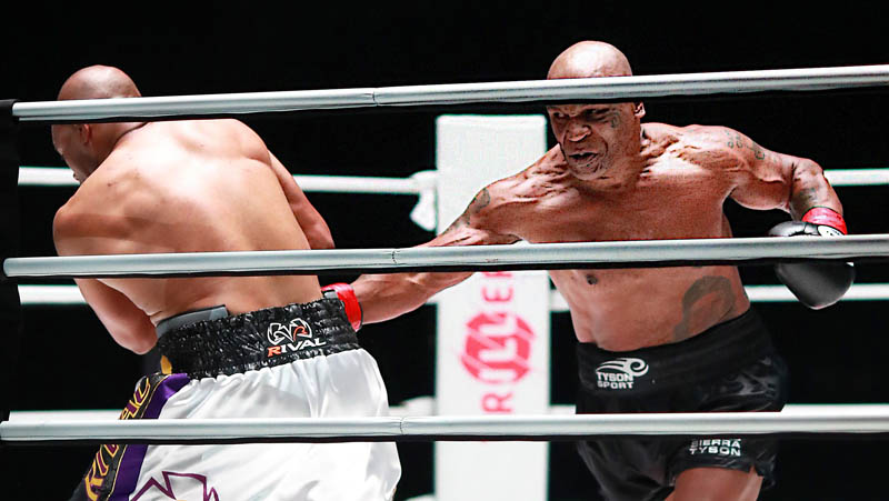 Mike Tyson Roy Jones Jr Mike Tyson (kanan) melepaskan pukulan ke arah perut Roy Jones Jr pada pertandingan di Staples Center, Los Angeles, Amerika Serikat (AS), Minggu (29/11/2020) siang WIB. (Foto: REUTERS)