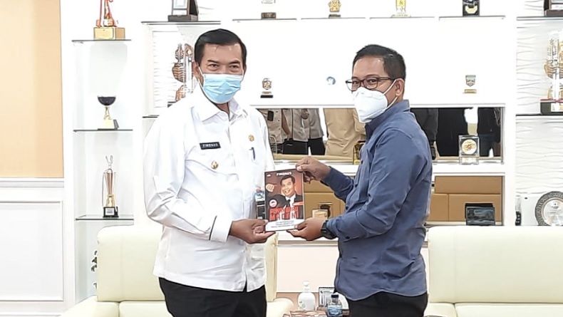Wali Kota Pekanbaru Firdaus (kiri) menyerahkan buku kepada Direktur Pemberitaan MNC Portal Indonesia Yadi Hendriana, Rabu (10/2/2021). (Foto: MNC Media).