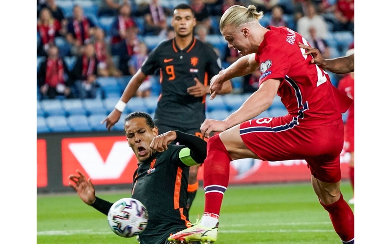 Bek Belanda Virgil van Dijk menghalau bola yang hendak dikuasai striker Norwegia Erling Haaland dalam laga Kualifikasi Piala Dunia 2022 di Stadion Ullevaal, Kamis (2/9/2021). (Foto: REUTERS/Stian Lysberg Solum/NTB)
