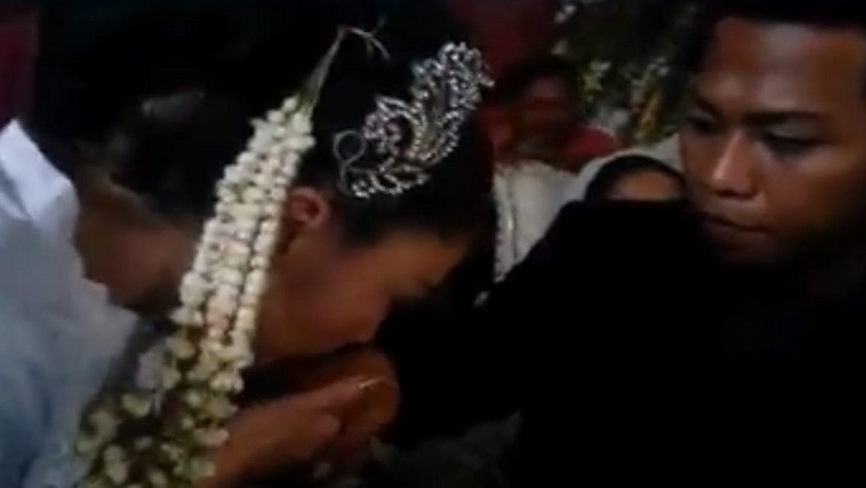 JAWA VS JEPANG1 Pengantin wanita asal Jepang, Yuriko Akagawa mencium tangan suaminya Maufur seusai akad nikah dinyatakan sah. (Foto: tangkapan layar)