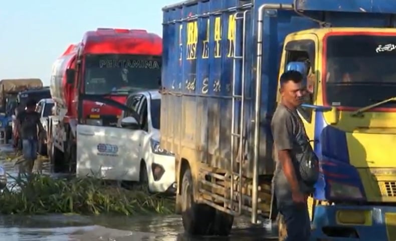 Jalan Trans Kalimantan Banjir 1 Jalan Trans Kalimantan di Pulang Pisau, Kalimantan Tengah terendam banjir hingga kendaraan antre berjam-jam. (Foto: iNews/Ade Sata)