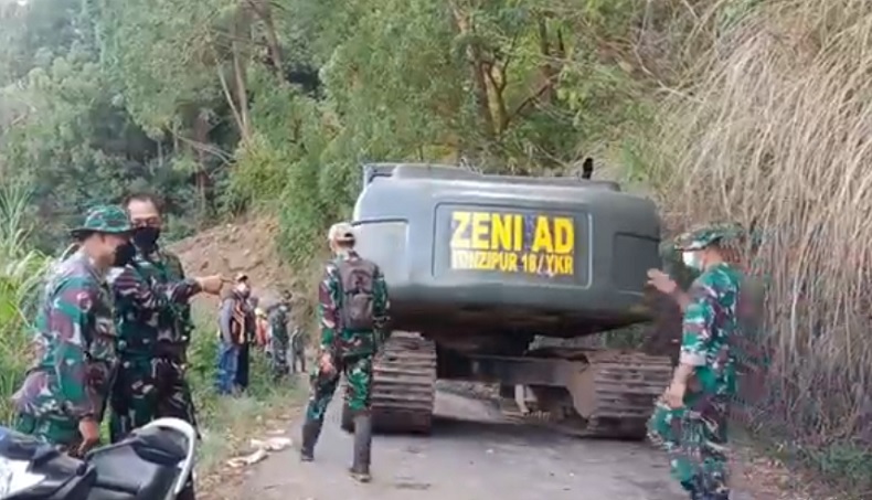 Alat berat longsor Alat berat milik TNI AD dikerahkan untuk membersihkan akses jalan yang tertutup longsor di Kintamani, Bangli. (Foto: iNews/Ari Wiradarma)
