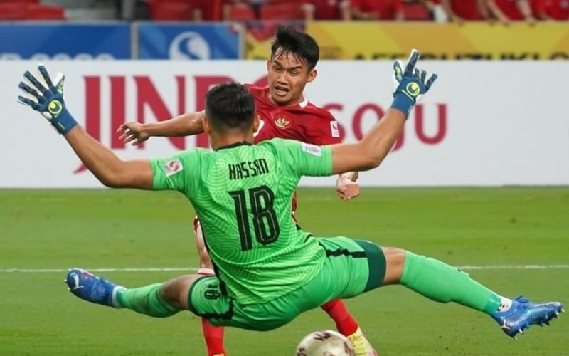 Winger Timnas Indonesia, Witan Sulaeman dihadang kiper Singapura, Hassan Sunny saat kedua bertempur di laga leg kedua semifinal Piala AFF 2020 di Stadion National, Sabtu (25/12/2021). (Foto: Instagram/@PSSI)