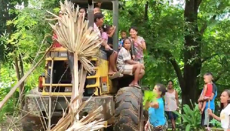 Emak-emak dan anak-anak menduduki alat berat loader milik Dinas PUPR Sikka. (Foto: iNews/Joni Nura).