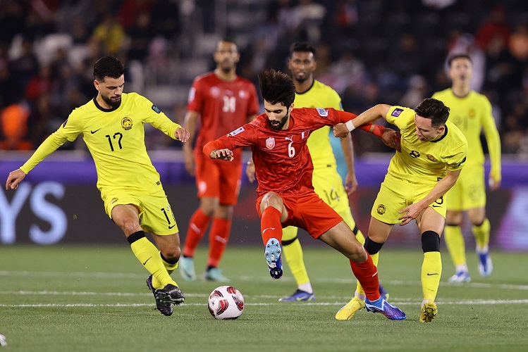 Duo Timnas Malaysia Paulo Josue (17) dan Stuart Wilkin (8) mengganggu pemain Bahrain Mohammed Al Hardan pada matchday 2 Piala Asia 2023 di Stadion Jassim bin Hamad, Al Rayyan, Qatar, Sabtu (20/1/2024) malam. (Foto: REUTERS/Ibraheem Al Omari)