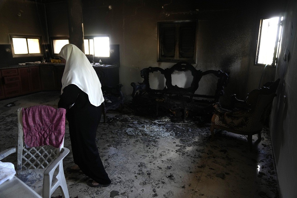 Seorang perempuan Palestina berdiri di dalam rumahnya yang dibakar para pemukim Yahudi Israel di Desa Jit, Tepi Barat, Jumat, 16 Agustus 2024. (Foto: AP)