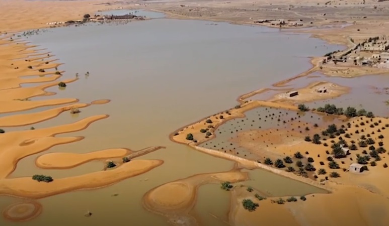 Pemandangan danau yang disebabkan oleh hujan lebat di antara bukit pasir di kota gurun Merzouga, Maroko tenggara. (Foto: AP)