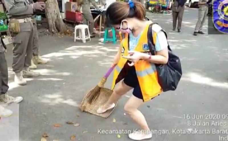 Viral Video Perempuan Pelanggar PSBB Terlihat Jijik Menyapu Jalan di Jakbar