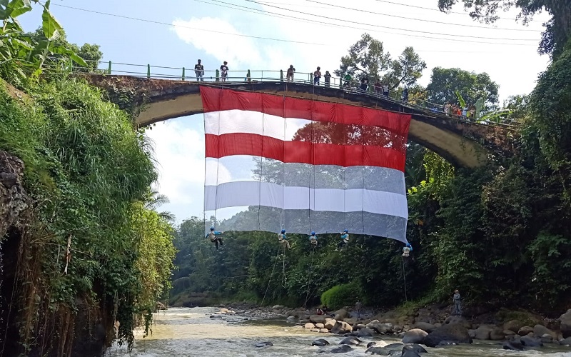Wow, Bendera Merah Putih Berukuran Jumbo Berkibar di Jembatan Wisata Lolong