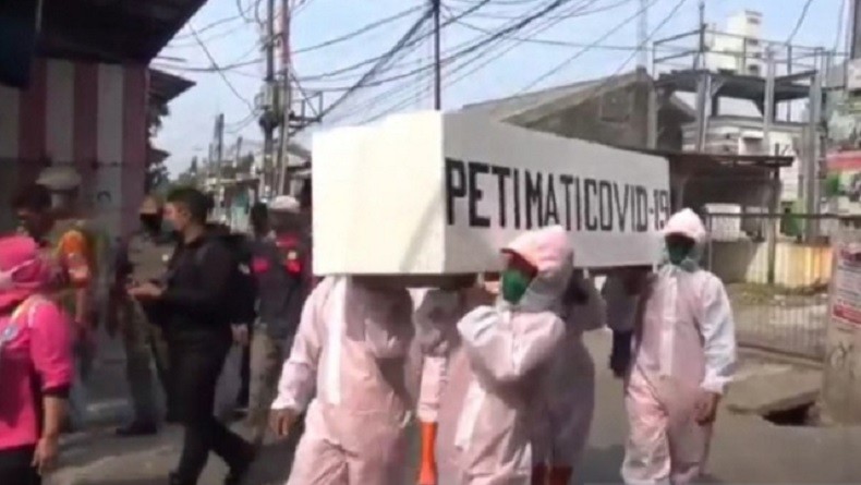 Petugas Pemkot Jaktim Arak Peti Jenazah Ingatkan Warga Bahaya Covid-19