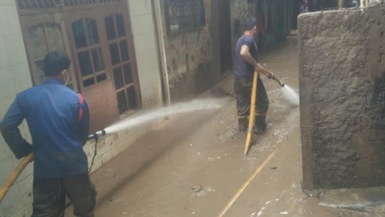 Petugas Damkar Bantu Semprot Lumpur Sisa Banjir di Permukiman Warga Jakarta Timur