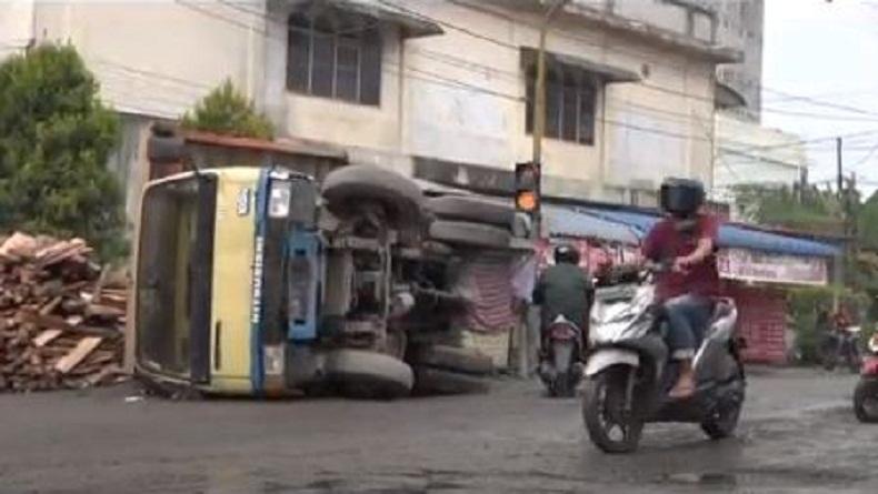 Lintasi Jalan Rusak, Truk Pengangkut Kayu Terguling di Tebingtinggi