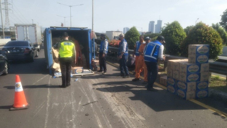Truk Penuh Muatan Dus Air Mineral Terguling di Samping GT Tol Meruya Selatan 2