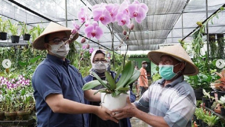 Pakai Caping saat Rintik Hujan, Anies Bersama Keluarga Keliling Taman Anggrek Ragunan