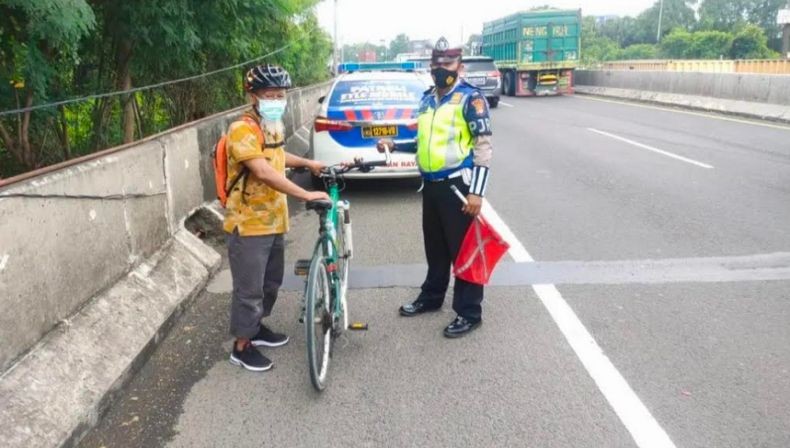 Pria Berpakaian Batik Nekat Gowes Masuk Tol Sedyatmo