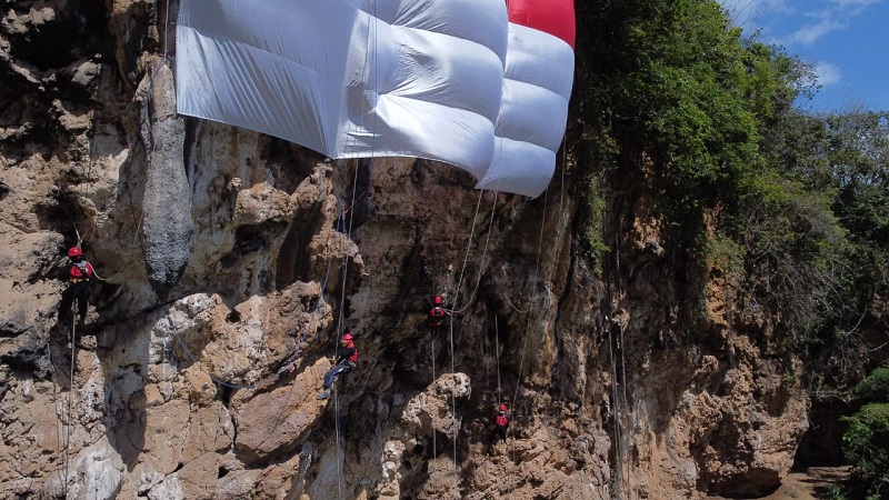 4 Atlet Panjat Tebing Muda Kibarkan Merah Putih Raksasa di Bukit Lembah Kera Malang 