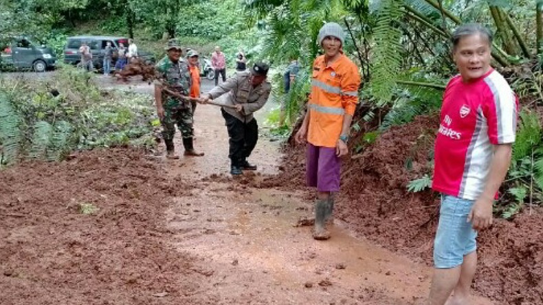 Polisi Bersama TNI dan Warga Kompak Bersihkan Material Longsor di Minahasa
