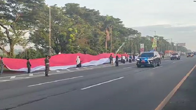 Jokowi Melintas, Jemaah 1 Abad NU Bentangkan Bendera Merah Putih Panjang di Rest Area Tol Surabaya