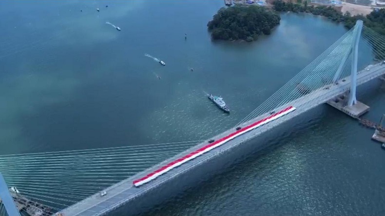 Polri Bentangkan Bendera Merah Putih Raksasa di Jembatan Pulau Balang