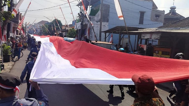Kirab HUT RI di Malang, Linmas Bentangkan Bendera Merah Putih Raksasa Sepanjang 79 Meter