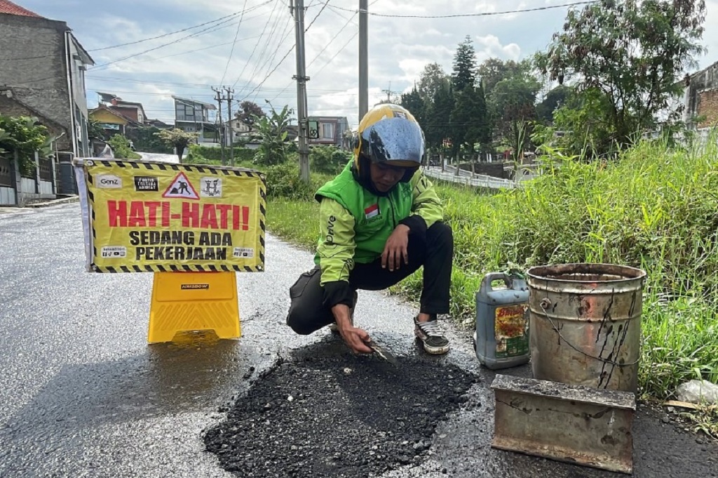 Viral Aksi Ojol di Bandung Tambal Jalan Berlubang Pakai Uang Pribadi Hasil Narik