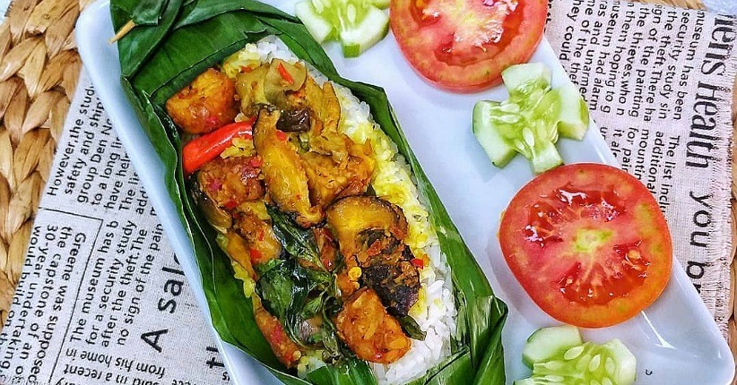 Gambar ini menampilkan nasi bakar jamur yang disajikan dalam daun pisang, memberikan aroma harum dan rasa gurih yang khas. Cocok untuk santapan keluarga atau acara spesial