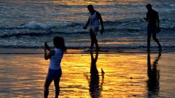 Wisatawan Menikmati Matahari Terbenam di Pantai Kuta Bali