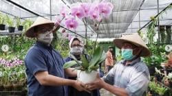 Pakai Caping saat Rintik Hujan, Anies Bersama Keluarga Keliling Taman Anggrek Ragunan