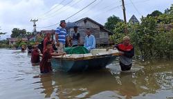 Jenazah Warga Dibawa dengan Perahu Melintasi Banjir di Kalimantan Barat