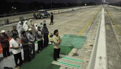 Warga Bekasi Sholat Berjemaah di Tengah Jalan Tol Jatikarya