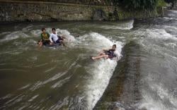 Serunya Bermain Air dengan Ban Karet di Sungai Ciliwung