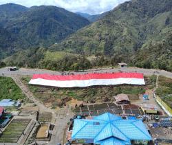 Satgas Yonif PR 330/Tri Dharma Bersama Masyarakat Bentangkan Bendera Raksasa di Sarang OPM