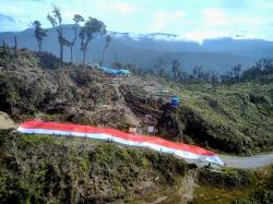 Sukacita Sambut Bulan Desember, Satgas 330 dan Masyarakat Bentangkan Bendera Merah Putih Raksasa