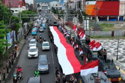 Ditsamapta Polda Sulut Bentangkan Bendera Merah Putih Berukuran 79 Meter di Boulevard Manado