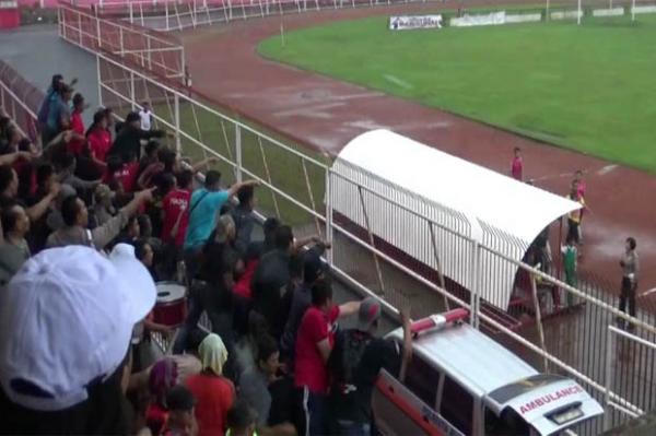 Suporter kedua kesebelasan melemparkan botol air mineral ke pemain dan official saat laga sepak bola antara Polres Blitar.