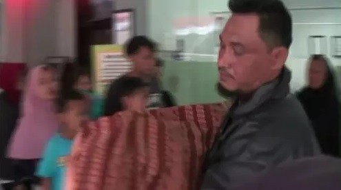 Supriyadi membopong jenazah keponakannya Muhammad Husein, korban tenggelam di Sungai Cisadane, viral di media sosial karena ditolak menggunakan ambulans. (Foto: ist)