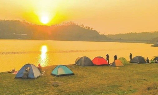 Pemandangan indah Waduk Sermo dengan air yang tenang dan dikelilingi perbukitan hijau