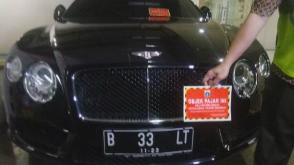 Badan Pajak Retribusi Daerah (BPRD) Jakarta Utara dan Komisi Pemberantasan Korupsi (KPK) menyegel 11 mobil mewah karena menunggak pajak yang terparkir di Apartemen Regatta, Penjaringan, Jakarta Utara, Kamis (5/12/2019). (Foto: iNews.id/Irfan Ma'ruf)