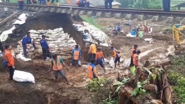 Sejumlah pekerja melakjukan perbaikan sementara pascalongsor yang mengakibatkan rel kereta tergantung di Sukabumi, Jawa Barat, Sabtu (7/1/202019). (Foto: iNews/Wilda Topan)