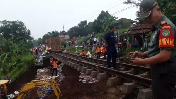 Sejumlah pekerja menimbun jalur rel kereta api yang longsor sehingga mengakibatkan rel kereta tergantung di Sukabumi, Jawa Barat, Sabtu (7/1/202019). (Foto: iNews/Wilda Topan)