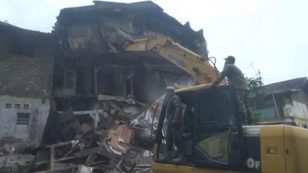 Alat berat merobohkan bangunan rumah warga di kawasan Tamansari, Kota Bandung, Jawa Barat (Jabar), Kamis (12/12/2019). (Foto: iNews/Billy Maulana Finkran)